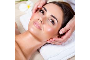 Spa therapist performing facial on client